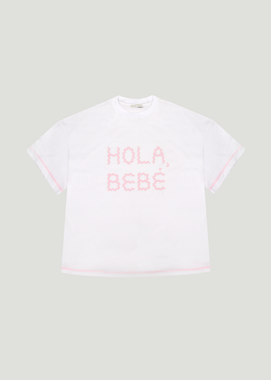 T-shirt 'Hola Bebé' od GOA Studio – figlarna koszulka o luźnym kroju z odważnym napisem 'Hola Bebé', pełna uroku i zadziornej energii. biało różowy t-shirt. GOA Studio’s 'Hola Bebé' T-shirt – a playful, relaxed-fit tee with a bold 'Hola Bebé' print, radiating charm and cheeky energy. T-shirt z nadrukiem jak She is Sunday