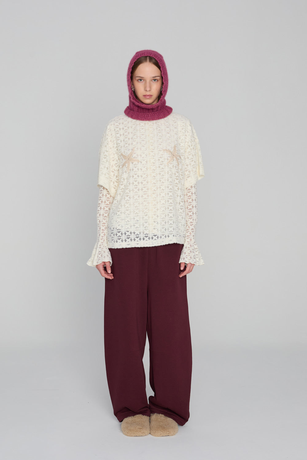 “Oversized lace-knit t-shirt in soft sheer fabric with embroidered starfish motifs, made in Poland, styled on a neutral background.”