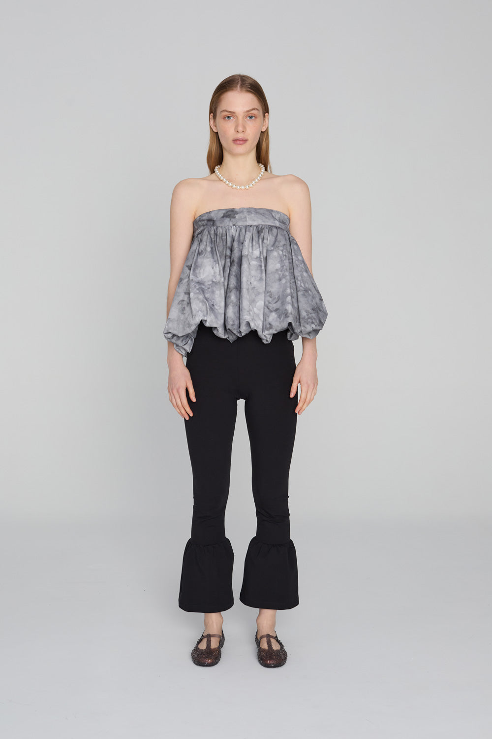 “Fitted 3/4-length leggins trousers with a wide flowing ruffle hem, in soft fabric that hugs like leggings with a comfortable waistband, styled on a clean background.”