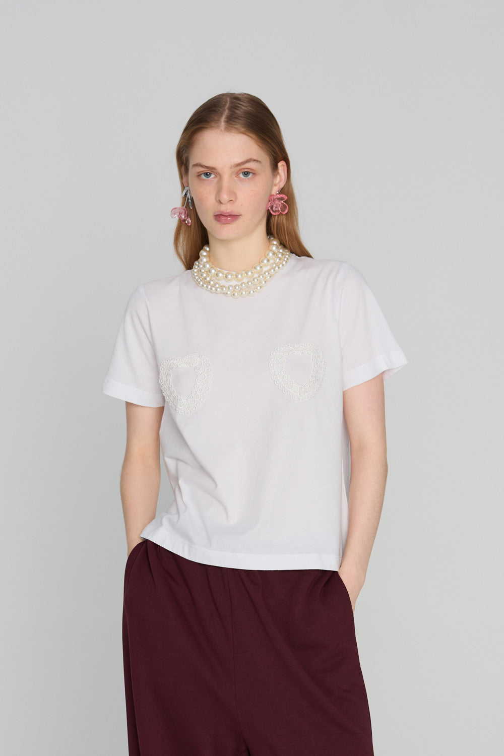Oversized soft t-shirt with a minimalist embroidered heart motif on the chest, photographed against a clean neutral background.