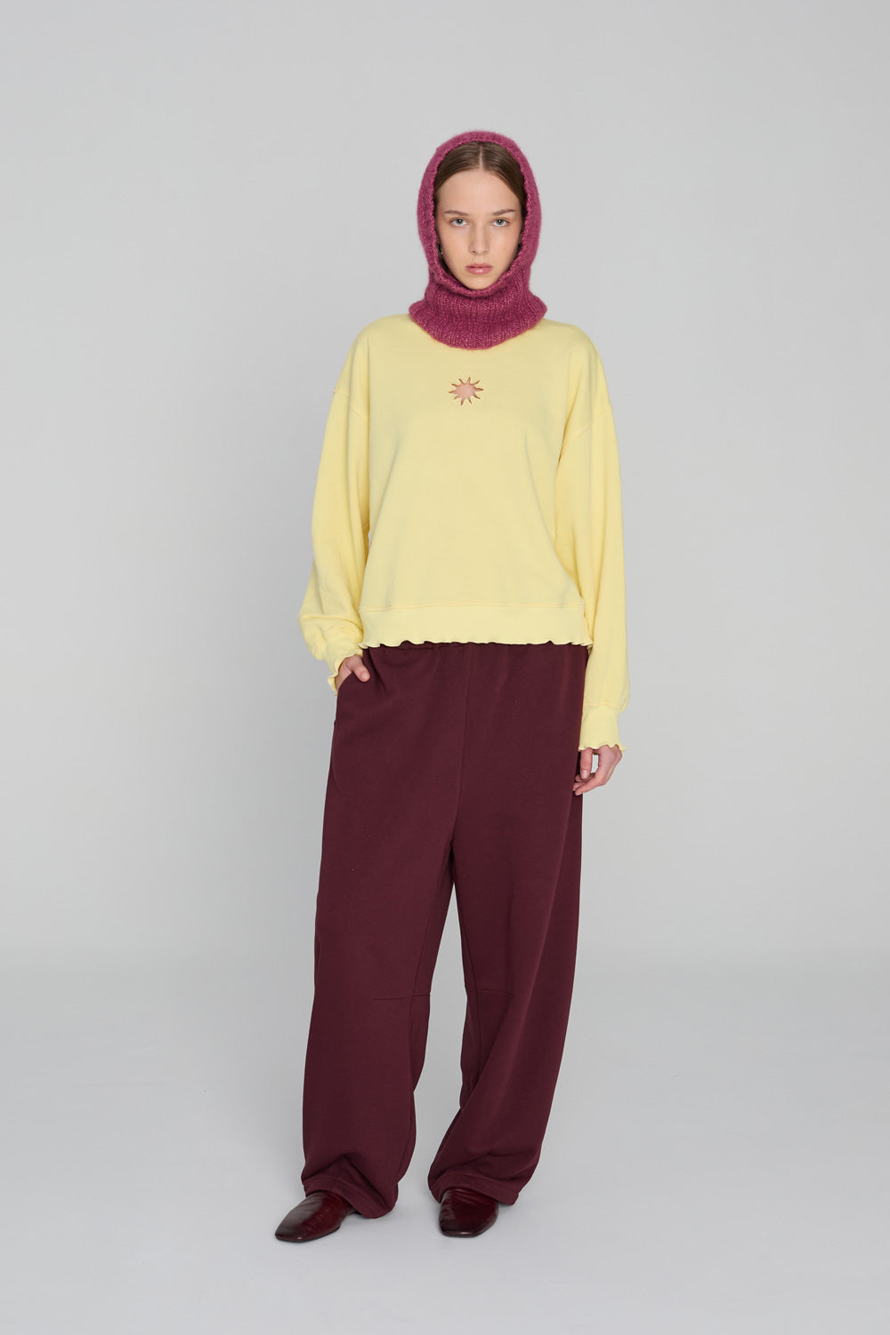 Soft sunny-yellow oversized hoodie with ruffled cuffs and a relaxed silhouette, photographed against a clean neutral background